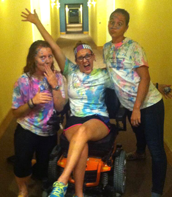 Kelsey and two friends make funny faces as they wear clothing covered in chalk