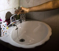 turning on faucet at bathroom sink