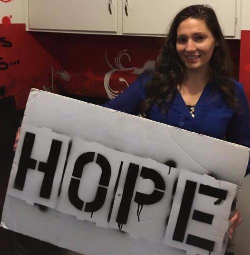 Photo of Azaria Wittekind holding the hope board