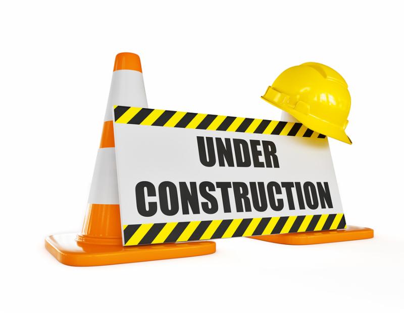 Under construction concept background - orange highway traffic construction cones with white stripes with announcement plate isolated on white