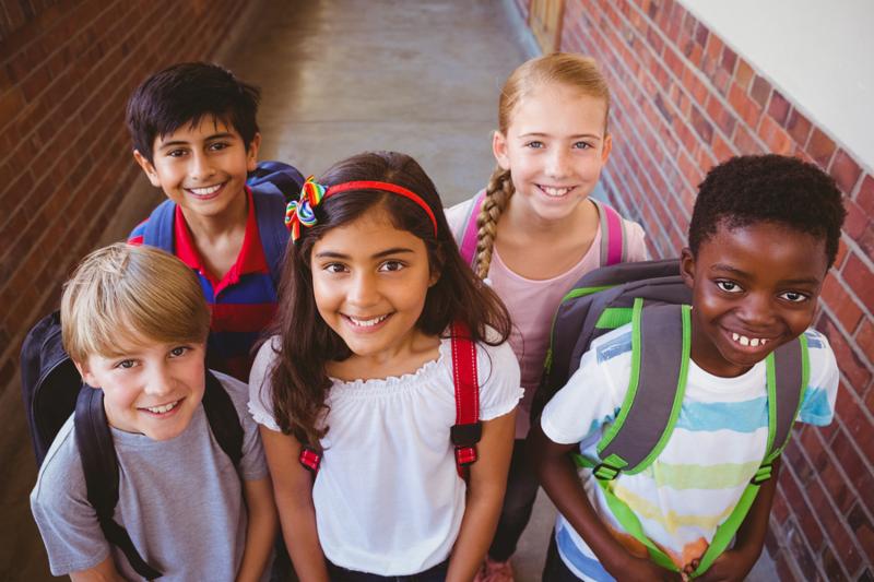 Portrait of smiling little school kids in school corridor