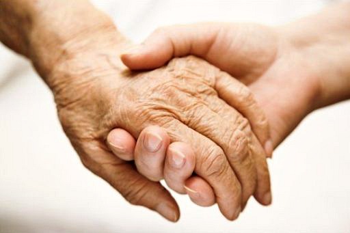 Aged hands, one holding another