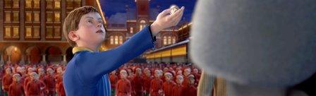 A boy, a sleigh bell in his hand, looking up at Santa
