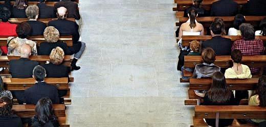 People in pews separated by a broad aisle.