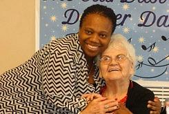 Caring staff hugging a smiling resident