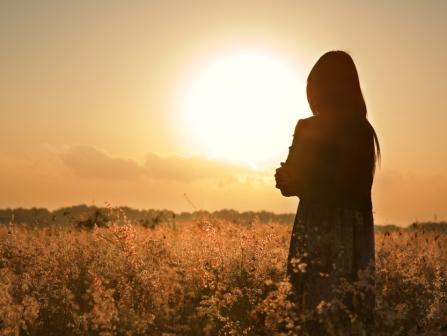 A lady looking off toward the rising son
