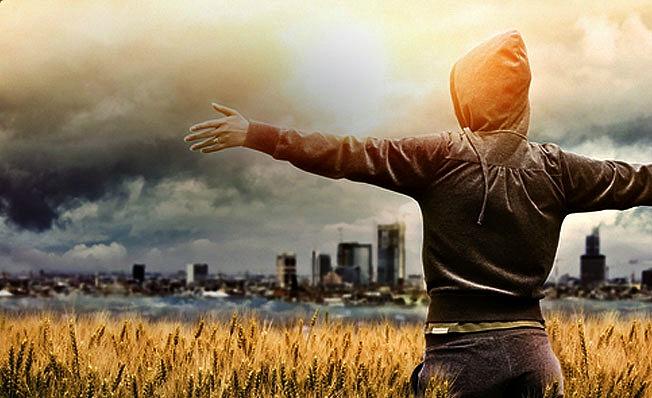 Woman with outstretched arms, looking over a city
