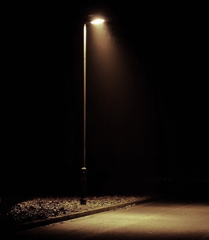 A single streetlamp shining in the darkness