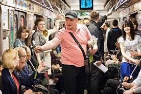 Man handing out flowers on a subway