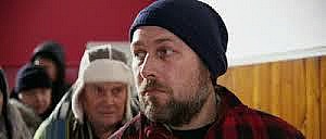 A middle-aged man in line at a soup kitchen