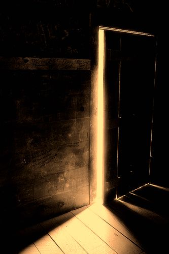 A darkened room, a door slightly open, and golden light streaming in