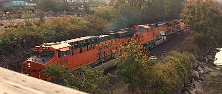 Three engine train passing under a bridge