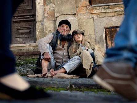 A homeless old man and child, looking at people pass them by