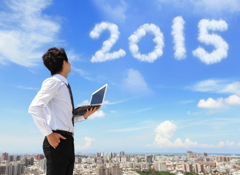 Young business man using laptop and look to 2015 year text with blue sky and cloud and cityscape in the background asian