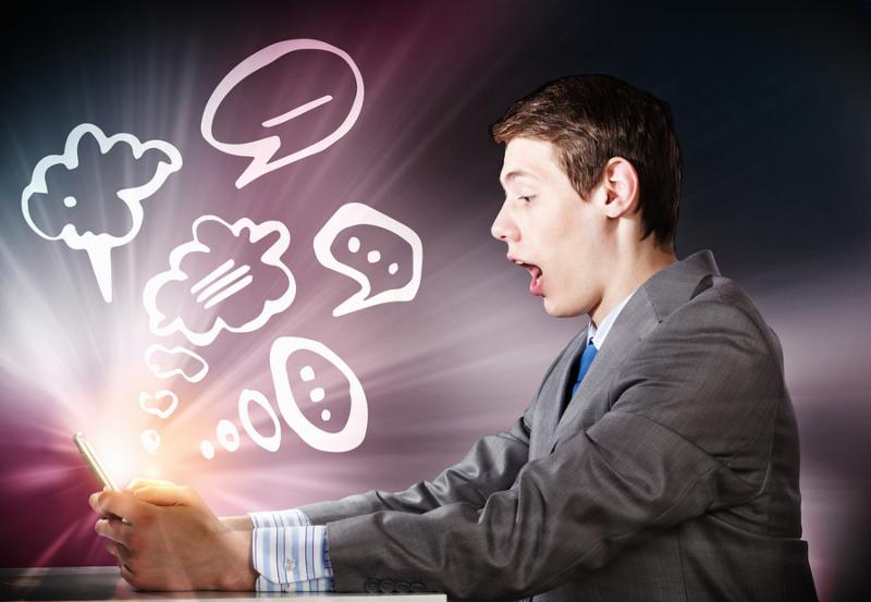 Young businessman looking shocked into tablet pc