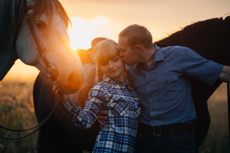 loving couple man and woman in a cowboy hat riding a horse
