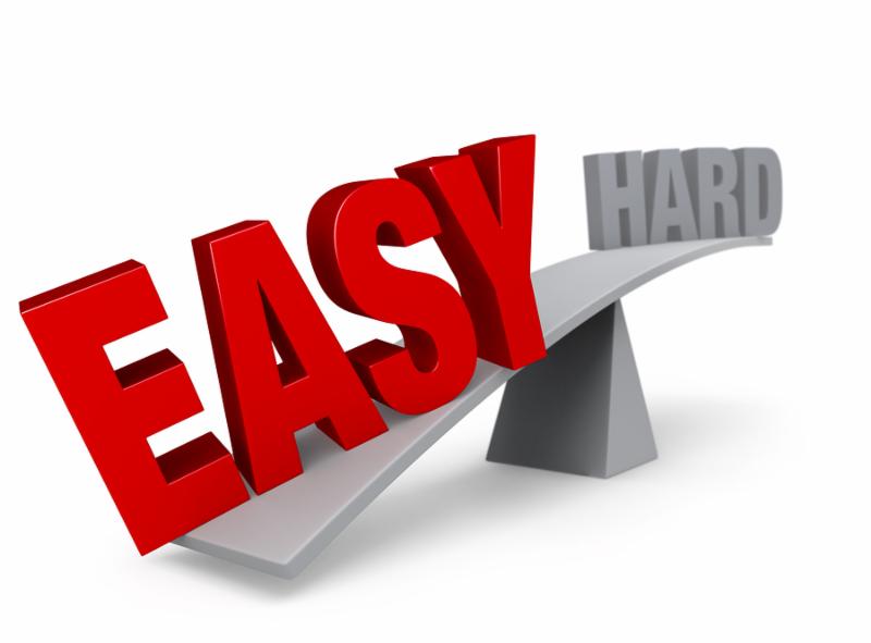 A bright red  EASY  weighs one end of a gray balance beam down while a gray  HARD  sits high in the air on the other end. Shallow DOF with focus on  EASY . Isolated on white.