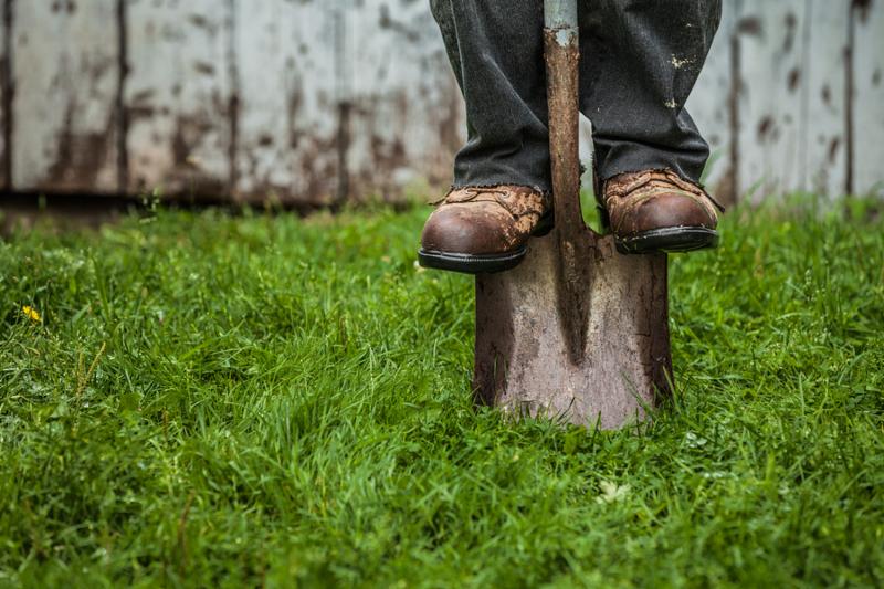 Details of feet and Shovel in front of Barn