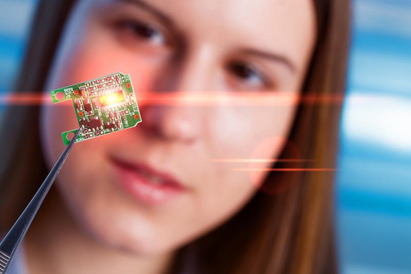 Girl shows new microchip on plate  that can be implanted into a paralyzed patient, developed a microchip muscle simulator
