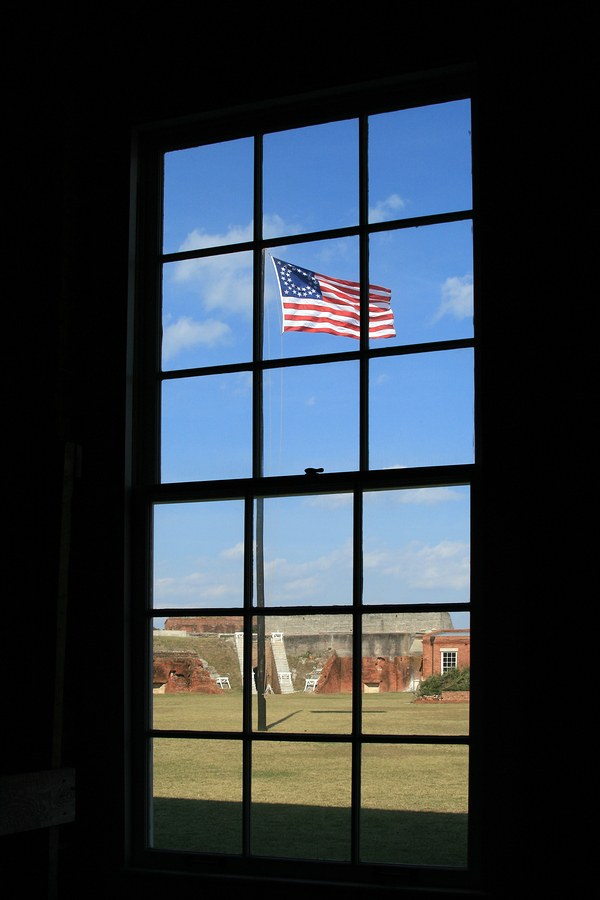 Vintage civil war flag as seen through window at historic Fort Clinch