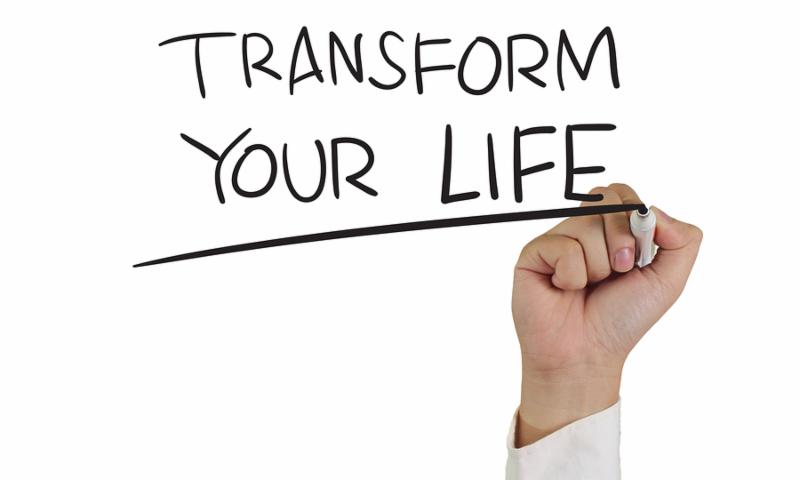 Motivational concept image of a hand holding marker and write Transform Your Life isolated on white