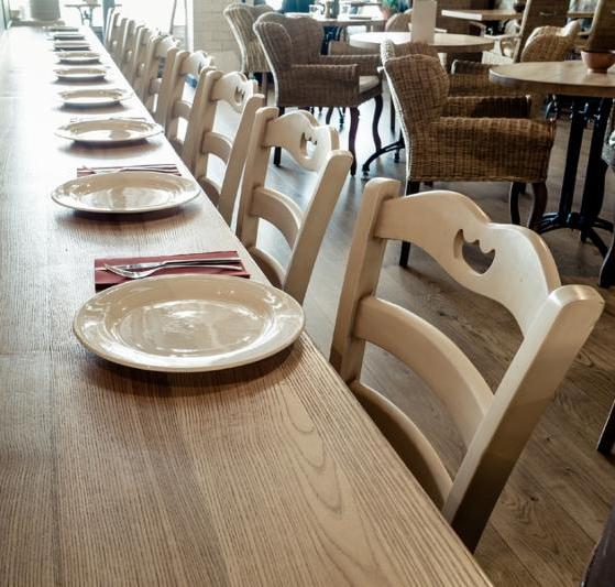 long wooden table decorated with dishware for banquet