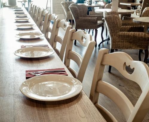 long wooden table decorated with dishware for banquet