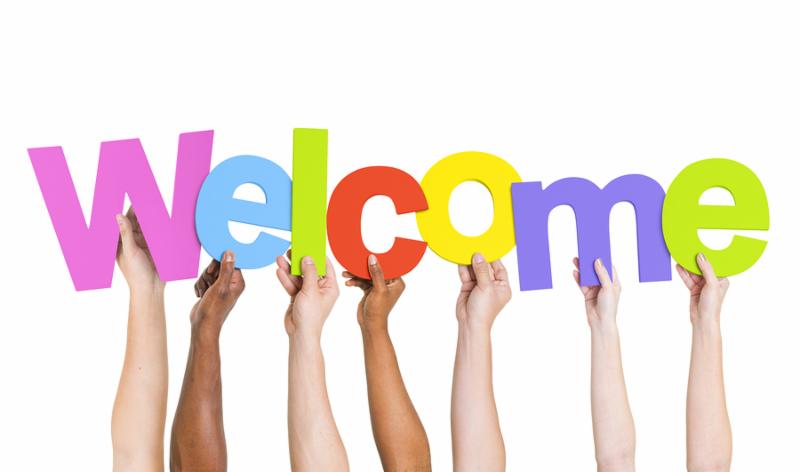 Multi-Ethnic Group Of People Holding The Word Welcome