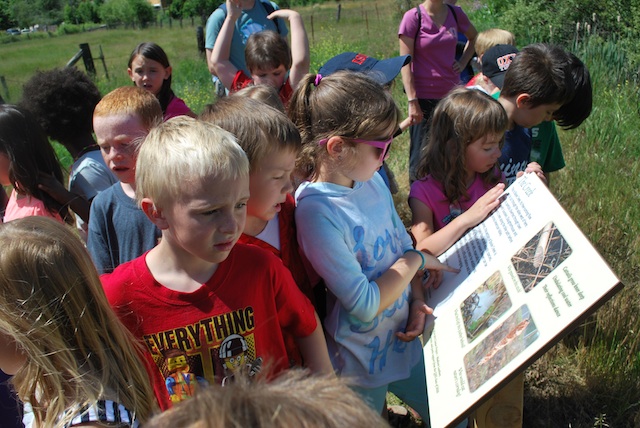 Children reading interpretive signs