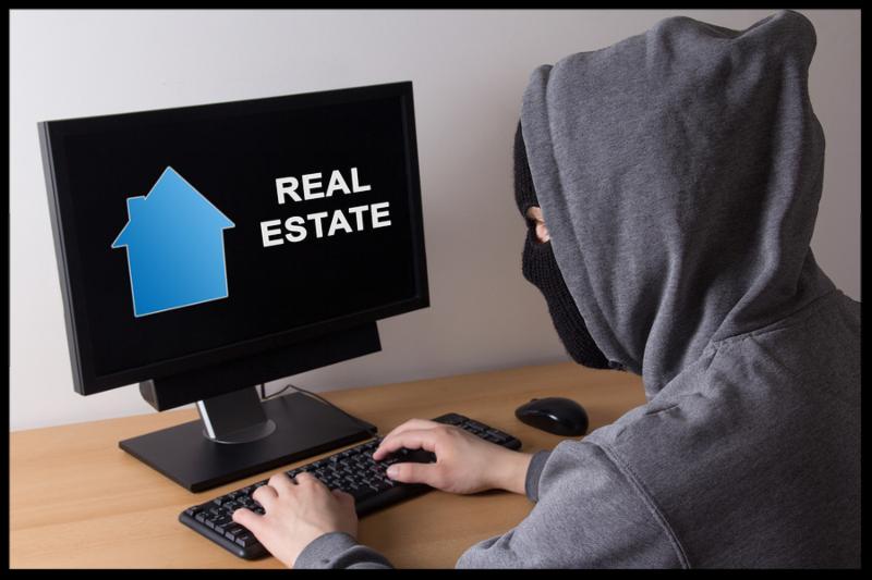 criminal and burglary concept - thief in mask searching info about real estate in internet