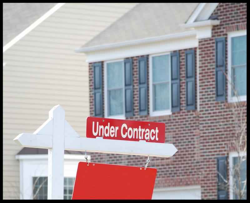 real estate for sale with under contract sign in red
