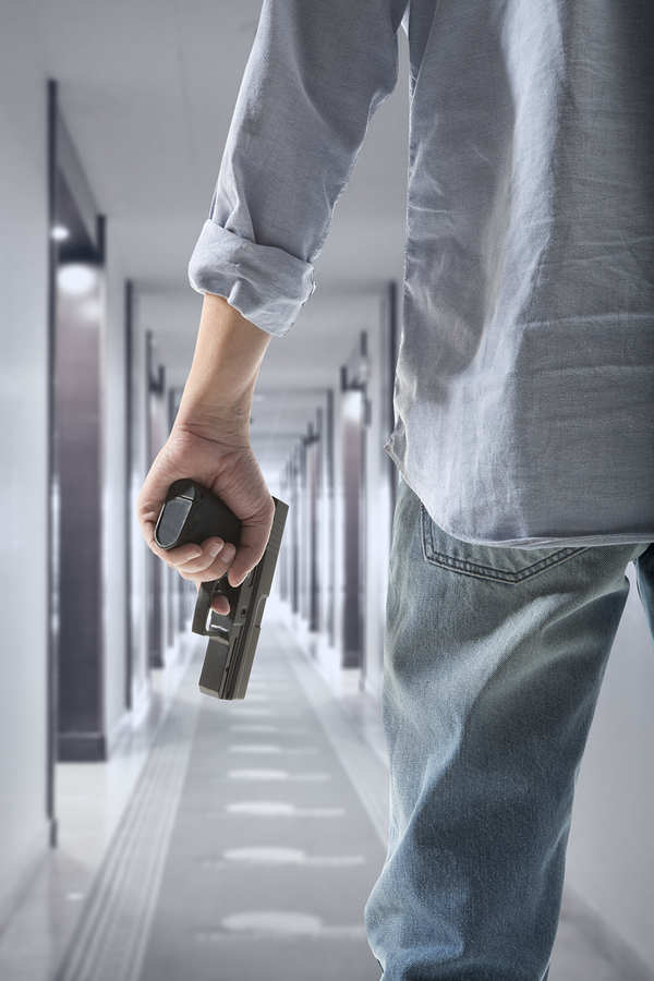 Man holding gun against an corridor background