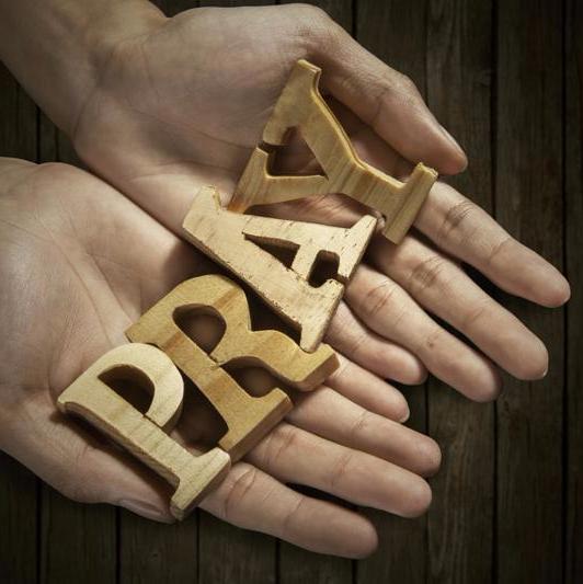 Man holding pray word in palm with wooden background