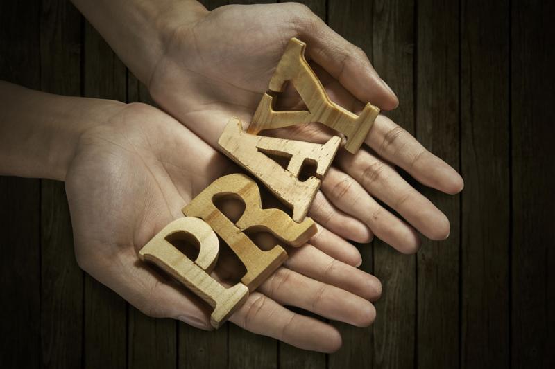 Man holding pray word in palm with wooden background