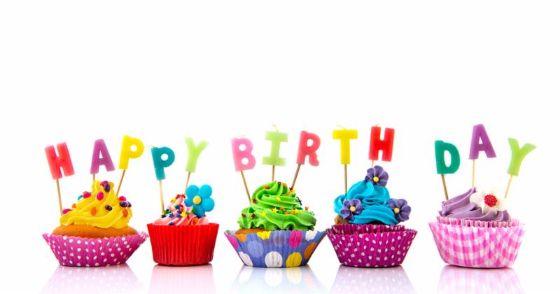 Colorful cupcakes with happy birthday candles isolated over white background