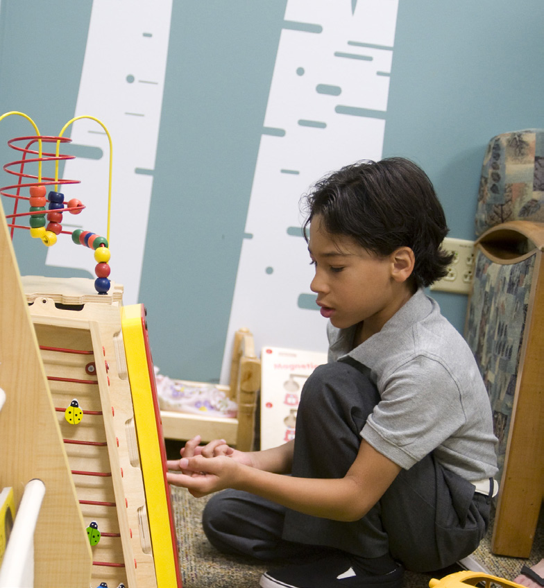 Max Hein, son of Kortnee Hein, to whom the UCH NICU Bright Space is dedicated, plays at after cutting the ribbon.