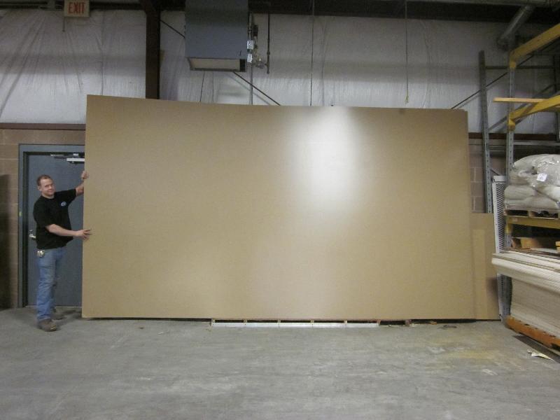 SmallCorp employee handling large acrylic sheets