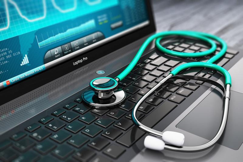 Laptop or notebook computer PC with medical cardiologic diagnostic test software on screen and stethoscope on black wooden business office table with selective focus effect