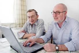 two men smiling at a laptop