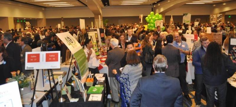 crowd of people looking a displays and talking to board members