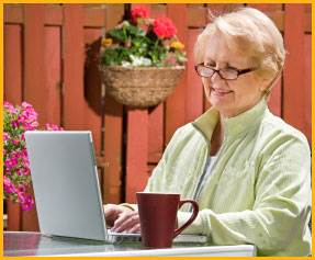smiling woman with laptop in garden