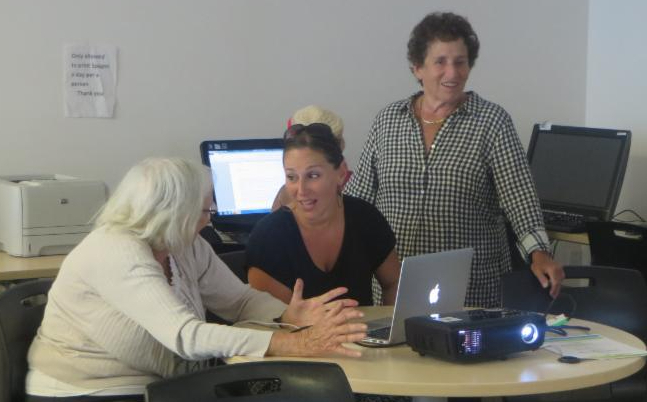 instructor with seniors at computer