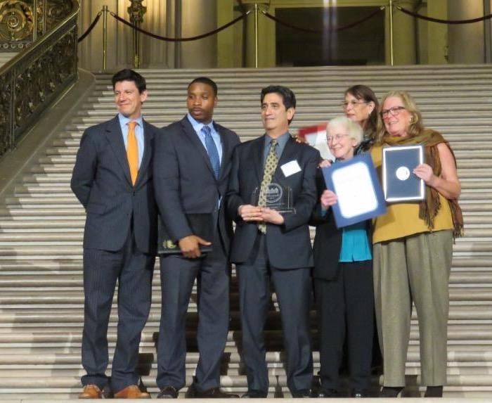 neighbors receiving award on city hall stairs