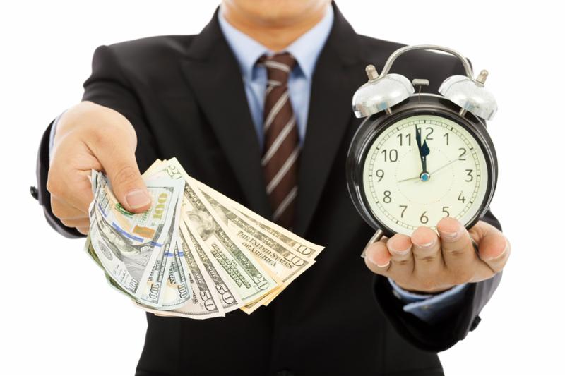 businessman holding money and clock. time is money concept     Note  Shallow depth of field