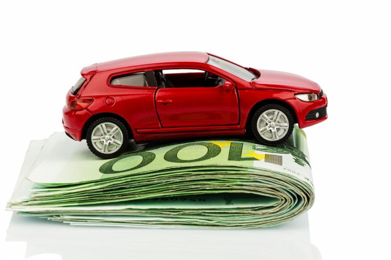 a car standing on euro bills. costs for the purchase of automobiles, gasoline, insurance and other car costs