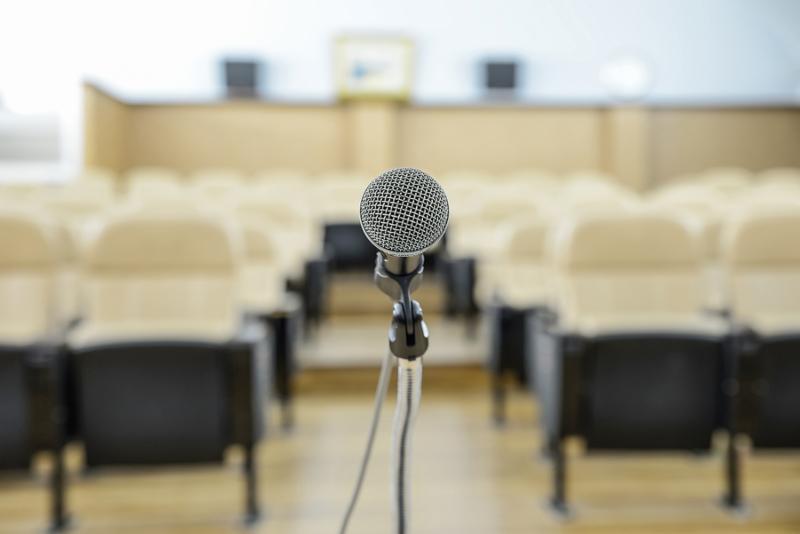 before a conference the microphones in front of empty chairs.     Note  Shallow depth of field
