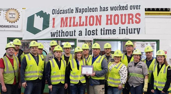 Employees in hardhats holding award plaque