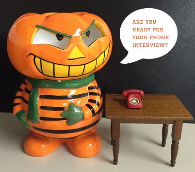 Scary pumpkin character next to a telephone