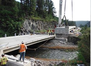 crane lifting concrete for bridge project