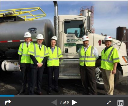 Prime Minister and employees standing in front of a truck
